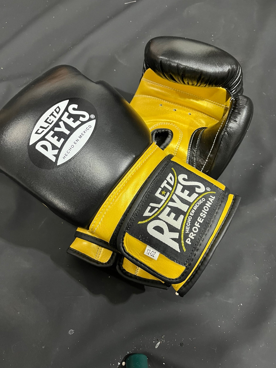 Black and gold professional boxing gloves angled detail view