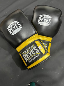 Black and gold professional boxing gloves front view