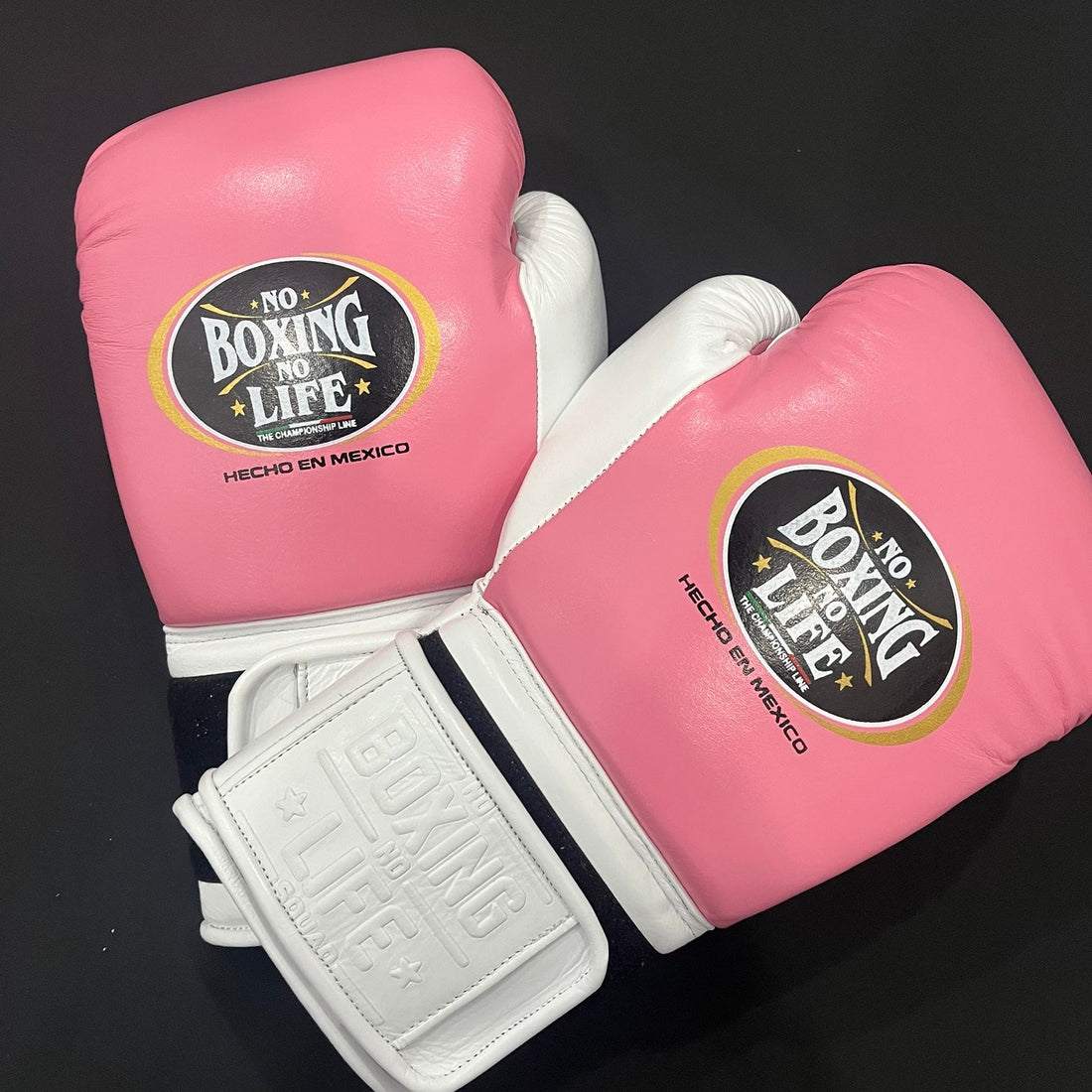 No Boxing No Life white and metallic pink lace-up boxing gloves angled view