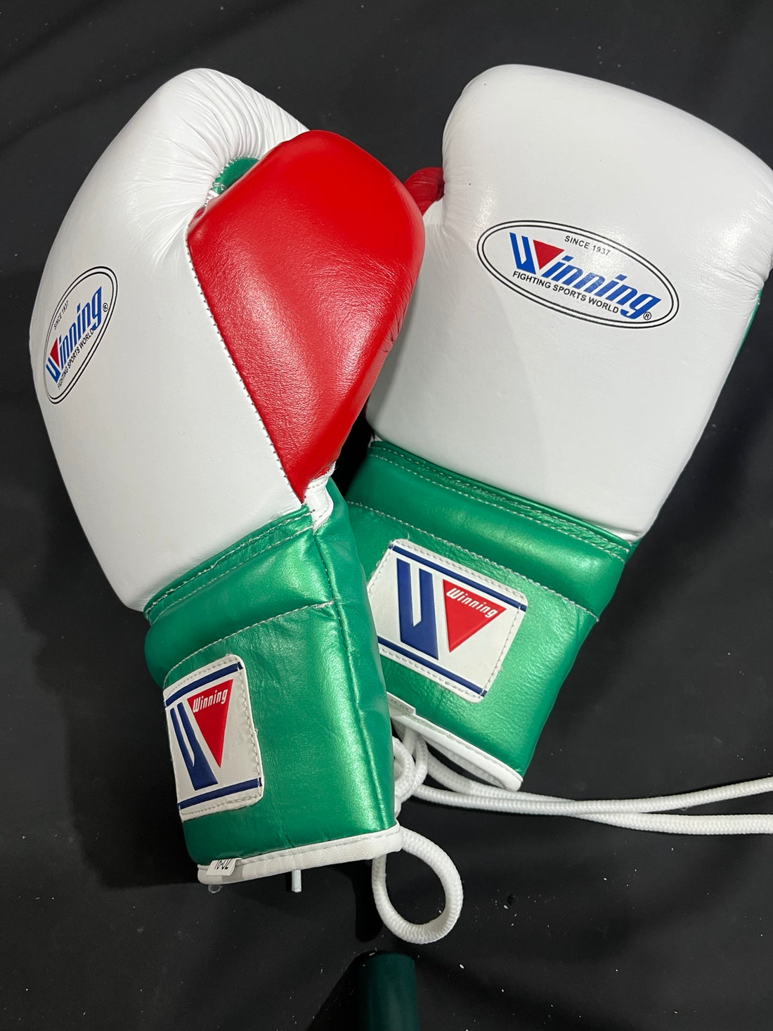 Winning white green and red lace-up boxing gloves angled pair view