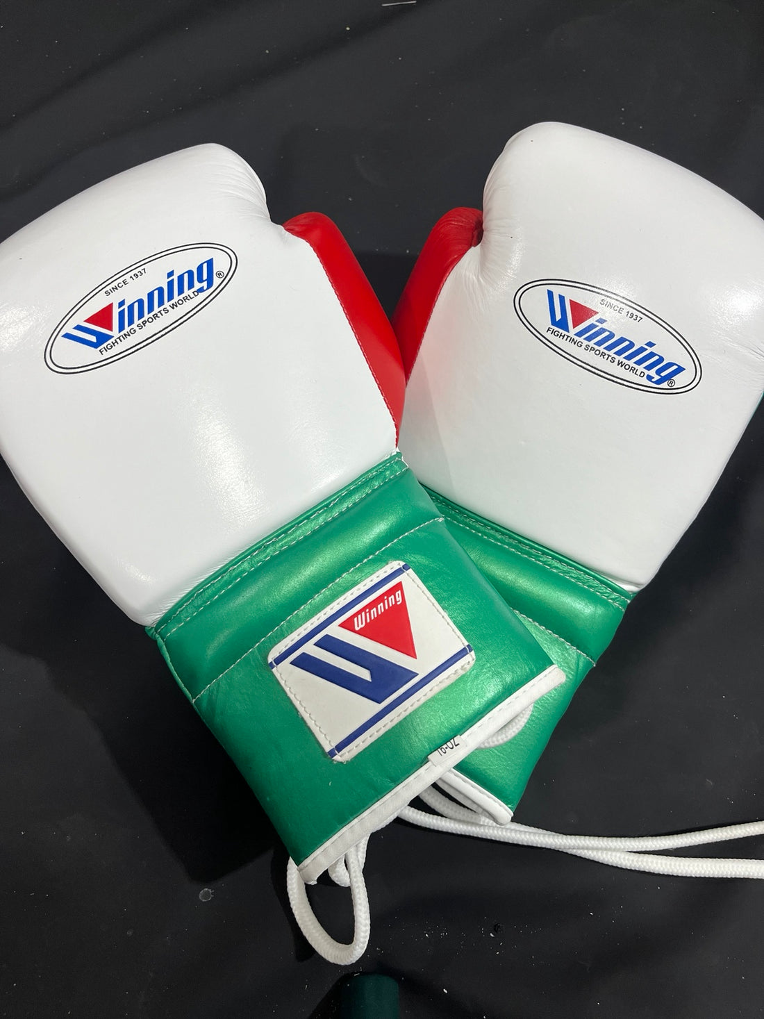 Winning white green and red lace-up boxing gloves front pair view